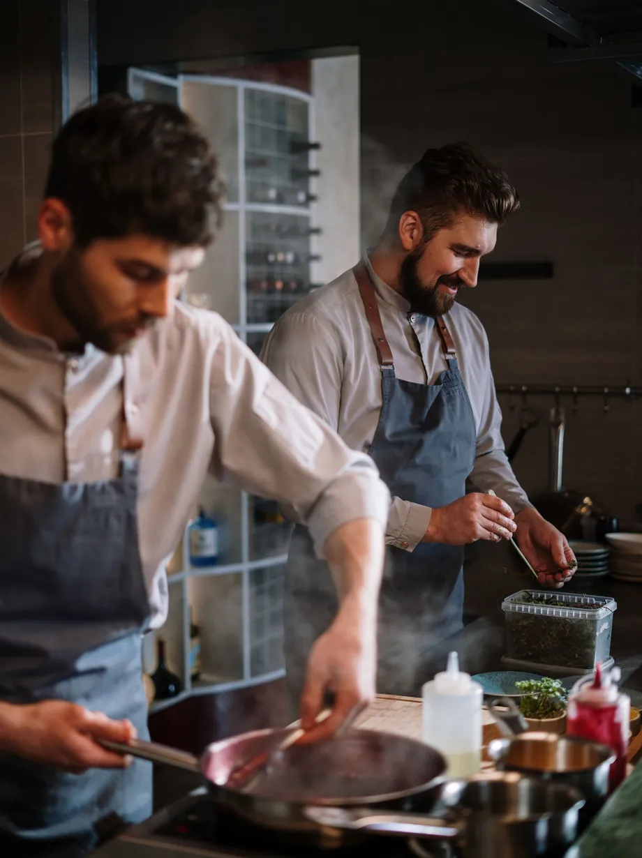 Dos cocineros trabajando en la cocina de Rescoldo