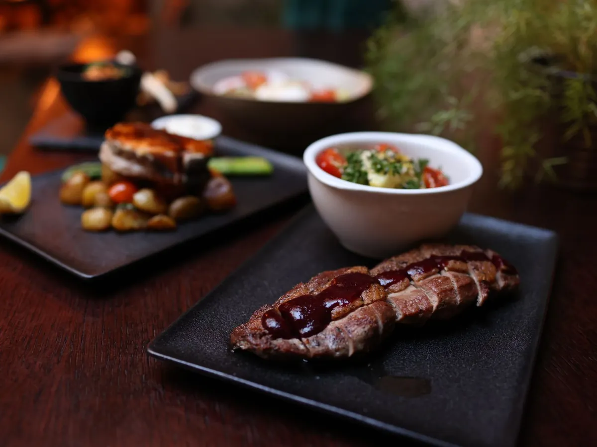 Presa ibérica hecha a la brasa y fileteada sobre plato de pizarra